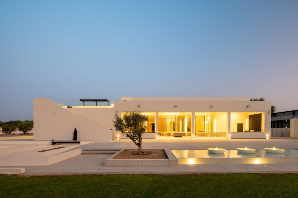 Luxury villa facade lighting in Bahrain with warm exterior illumination and palm trees