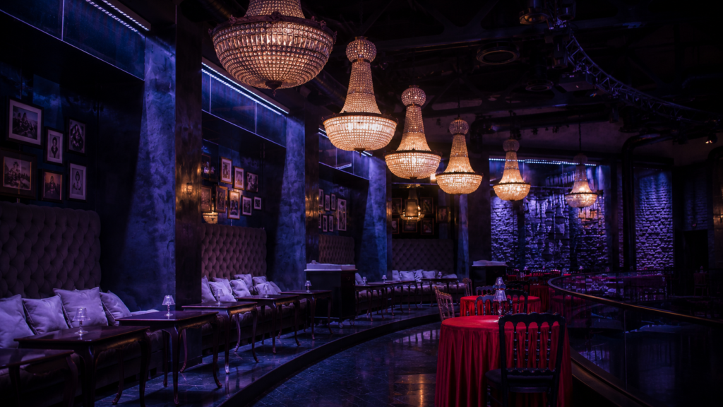 Luxury hospitality lighting design in a premium restaurant interior with crystal chandeliers, ambient mood lighting, and elegant dining setup